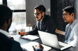 © DmitryStock - An Asian businessman in a stylish suit and glasses with an interpreter is holding a meeting with foreigners. Meeting at the office with large windows.