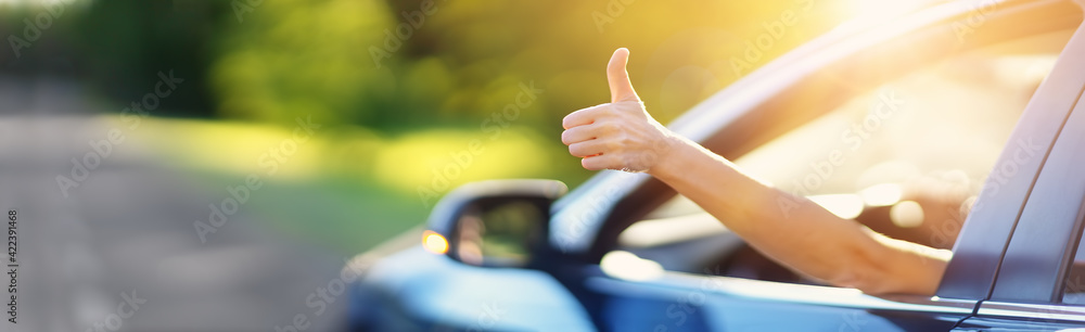 Woman inside her car gesticulate thumb up - obrazy, fototapety, plakaty 