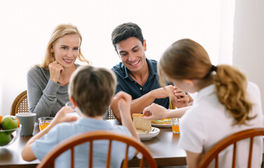 Wall Mural - Happy caucasian family with teenage daughter and son smiling and talking while having breakfast in modern kitchen. Family,healthy,fun and lifestyle concept.