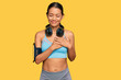 © Krakenimages.com - Beautiful hispanic woman wearing sportswear and headphones smiling with hands on chest with closed eyes and grateful gesture on face. health concept.