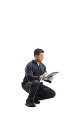 Wall Mural - Worker in a uniform kneeling and writing a document