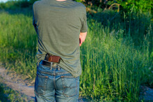 Hidden Weapon Gun In Jeans Pocket. Man With Weapon, Rear View