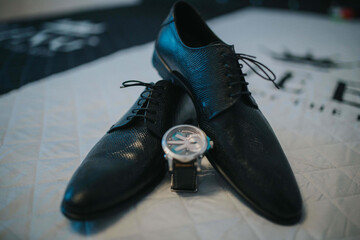 Poster - Selective focus of a pair of shoes and a wristwatch in the bed