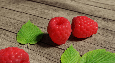 Wall Mural - summer still life with raspberries with green leaves on a wooden table