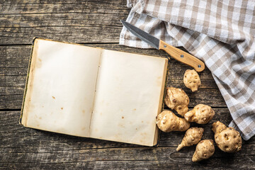 Canvas Print - Blank cookbook and raw jerusalem artichoke. Topinambur vegetable root.