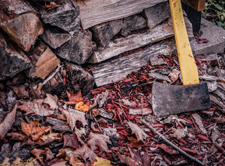 axe for cutting wood, timber, with pile of split log stacked and stored