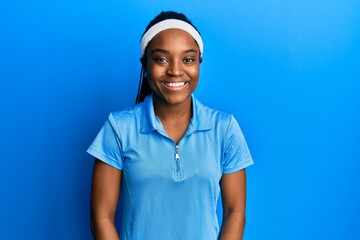 Wall Mural - African american woman with braided hair wearing tennis player uniform with a happy and cool smile on face. lucky person.