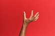 © Krakenimages.com - Hand of hispanic man over red isolated background picking and taking invisible thing, holding object with fingers showing space