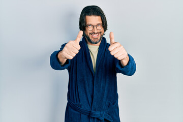 Sticker - Middle age caucasian man wearing bathrobe and glasses approving doing positive gesture with hand, thumbs up smiling and happy for success. winner gesture.