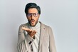 © Krakenimages.com - Young hispanic man wearing business jacket and glasses looking at the camera blowing a kiss with hand on air being lovely and sexy. love expression.