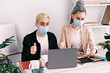 © domarevatanya - Business conference online. Young male manager and his assistant in jackets and medical masks using a laptop to hold a conference. Reporting to bosses about work done. Slow motion, 4k