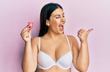 Sticker - Beautiful brunette woman holding menstrual cup wearing underwear celebrating crazy and amazed for success with open eyes screaming excited.