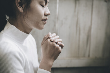 Wall Mural - Hand girl praying in the church, Hands folded in prayer concept for faith, spirituality and religion.  vintage tone.