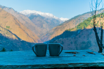 Wall Mural - two cups of coffee and the snow capped mountain range, pekhri, himachal pradesh, india