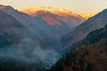 Wall Mural - sunset rays over the snow capped mountain peaks, pekhri, tirthan valley, himachal pradesh, india