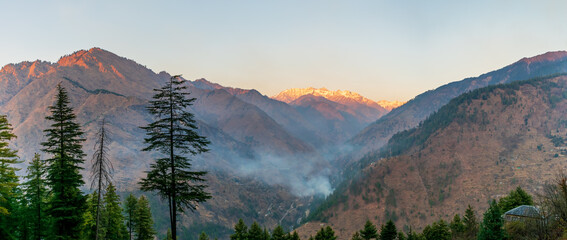 Wall Mural - sunset rays over the snow capped mountain peaks, pekhri, tirthan valley, himachal pradesh, india