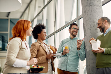 happy business team talking and having fun during lunch break at work.