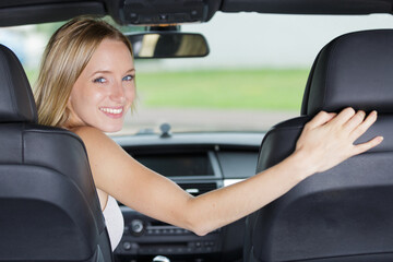 smiling woman sitting in a car and looking back