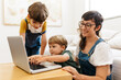 Mother with kids using laptop at home