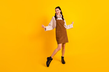 Sticker - Full size photo of nice brunette optimistic curly hairdo lady dance look empty space wear sweater overall shoes isolated on yellow background