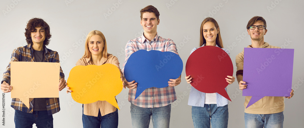 Voicing out our opinions. Young boys and girls showing on camera blank multicolored posters with speech bubble with place for text. Social media concept. Positive youth on a gray background. - obrazy, fototapety, plakaty 