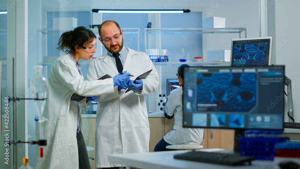 Scientists coworkers using digital tablet working in medical research ...