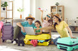© Studio Romantic - Happy excited family and daughter children buying payment for flight ticket booking hotel online using laptop with travel suitcase around at home living room. Holiday vacation traveling abroad concept