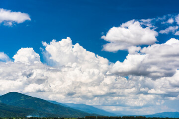 Wall Mural - Rolling mountains with blue sky and clouds background