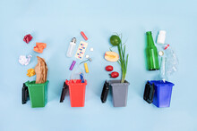 Trash Bins With Assorted Garbage On Blue Background-the Concept Of Recycling And Sorting Of Garbage