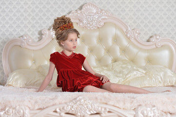 cute little girl in red dress lying on bed