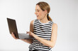 © Danko - Young casual woman holding a laptop computer isolated over white background.