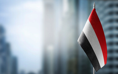 Wall Mural - A small flag of Yemen on the background of a blurred background