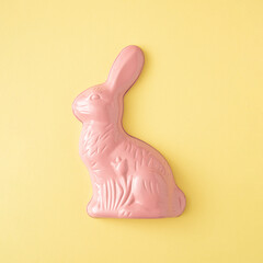 Wall Mural - Pink rabbit on a yellow background. Minimal Easter story.