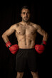 © robcartorres - athlete man training with boxing gloves on black background