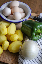 Raw Fresh Vegetables. Green Pepper, Onion, Potatoes And Eggs. Ingredients To Make Spanish Omelette