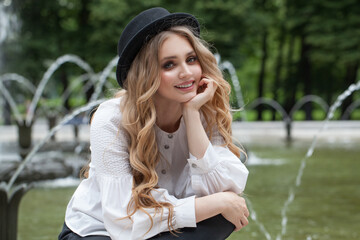 Wall Mural - happy blonde woman in black hat smiling outdoor
