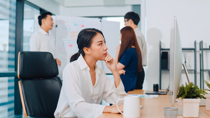 Wall Mural - Millennial young Chinese businesswoman working stress out with project research problem on computer desktop in meeting room at small modern office. Asia people occupational burnout syndrome concept.