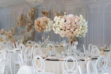 Festive wedding table setting with flowers, napkins, cutlery, glasses, bright summer table decor. Wedding decor