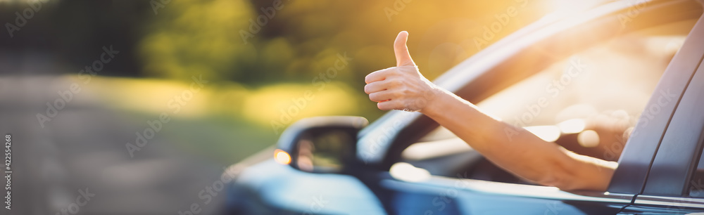 Woman inside her car gesticulate thumb up - obrazy, fototapety, plakaty 