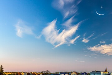 Wall Mural - beautiful dark fluffy cloudy sky with sun rays . crescent moon with beautiful sunset background
