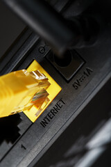 wireless modem router with yellow cable and lan port for connection on a black background.