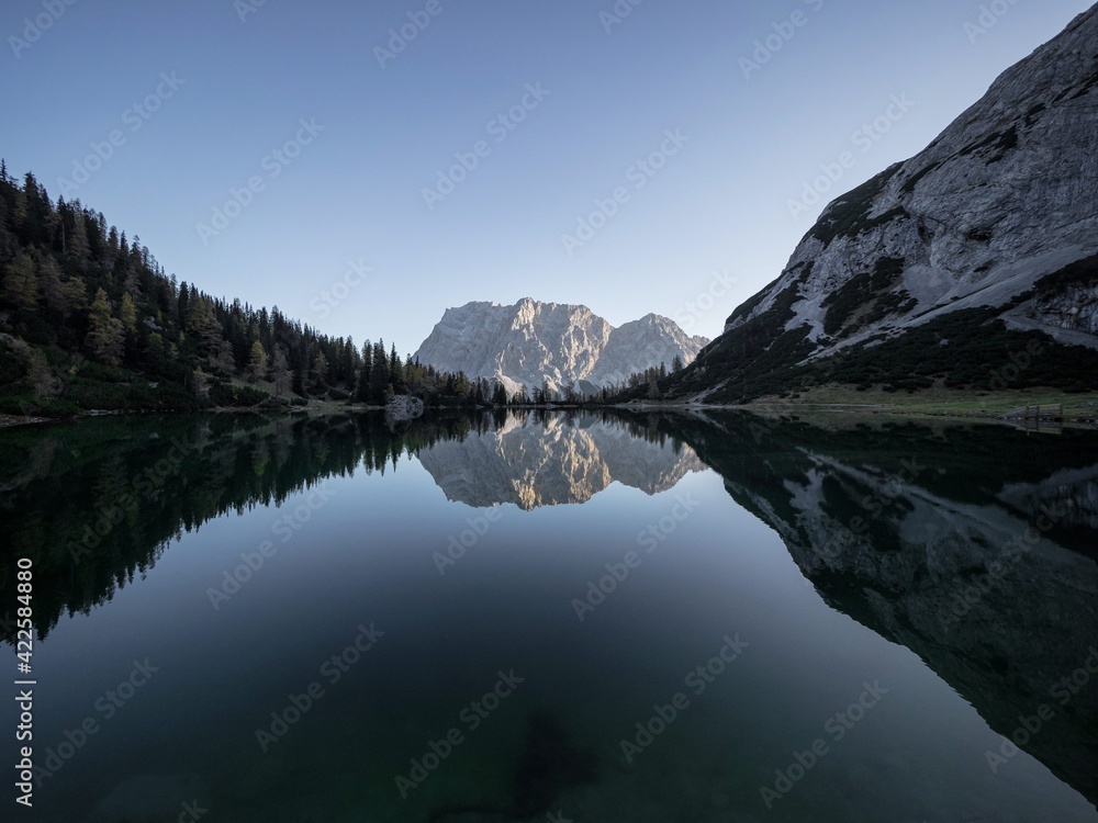 Sunrise mirror reflection of Zugspitze mountain massif in clear calm ...