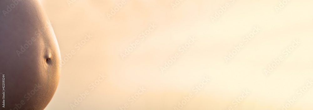 Background of a belly of a pregnant woman in warm light - obrazy, fototapety, plakaty 