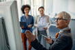 © Drazen - Mature businesswoman presenting strategy on whiteboard to female colleagues in the office.