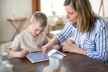 Wall Mural - Single mother with down syndrome son with tablet at home, distance learning.