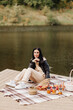© Natalia - brunette girl in a leather jacket beige pants and white sneakers on the lake