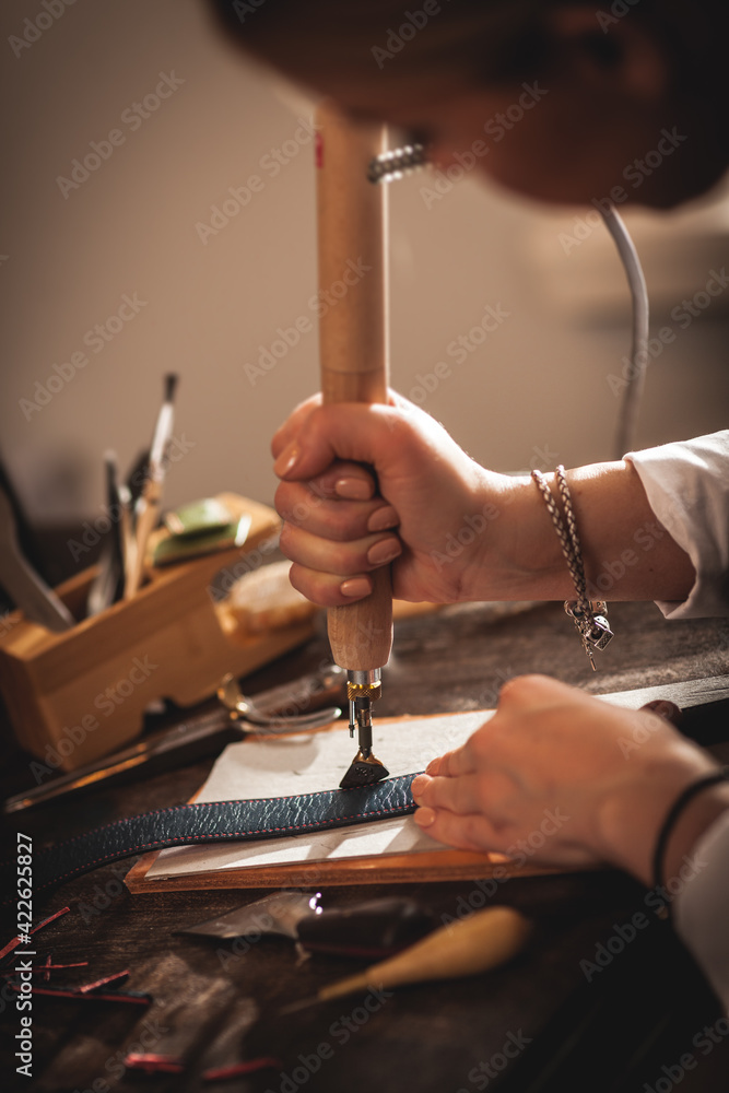 Leather handbag craftsman at work in a vintage workshop. Small business concept - obrazy, fototapety, plakaty 