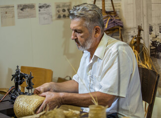 Canvas Print - Selective focus shot of a Caucasian man sewing with a sewing machine