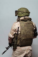 Russian military police soldier in desert uniform. Patch on the shoulder flag of Russia, arms of Russian army and the inscription Military Police in Russian. Shot in studio on a grey background.