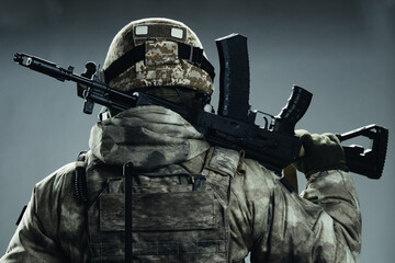 Poster - Male special forces soldier in grey winter uniform. Shot in studio on green background.